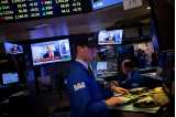 Trader på New York Stock Exchange står foran skærm, der viser da Dow Jones ramte 20.000