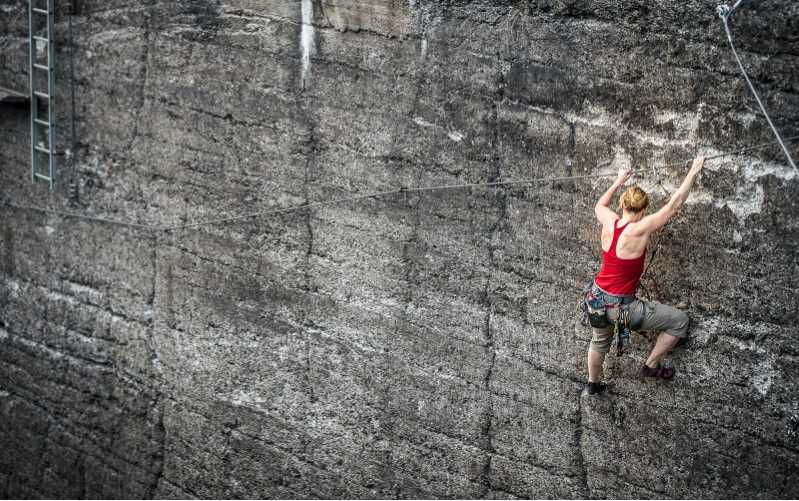Kvinde klatrer på bjergside