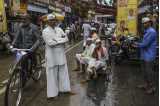 Foto af gadeliv i Mumbai. Til venstre en mand på cykel og i midten flere mænd som ser ind i kameraet.