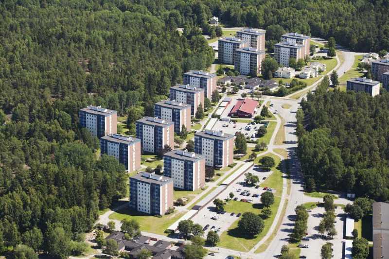Et lejlighedsområde omgivet af store grønne træer udenfor Stockholm.
