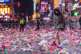 Kvinde går rundt i konfetti på Time Square efter nytårskonfettien er blevet skudt af.