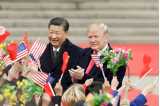 Præsident Jinping og Donald Trump i mørke jakker med viftende flag.
