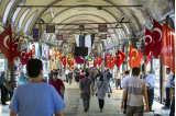Folk går på et marked, hvor der er tyrkiske flag