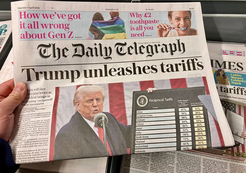 Framsidan av tidningen The Daily Telegraph med rubriken "Trump unleashes tariffs". Bilden visar Donald Trump som håller ett tal vid en mikrofon, framför en amerikansk flagga. Bredvid honom visas en tavla med titeln "Reciprocal Tariffs" och en lista över olika länder tillsammans med procentsatser. Tidningen är daterad torsdag 3 april 2025.